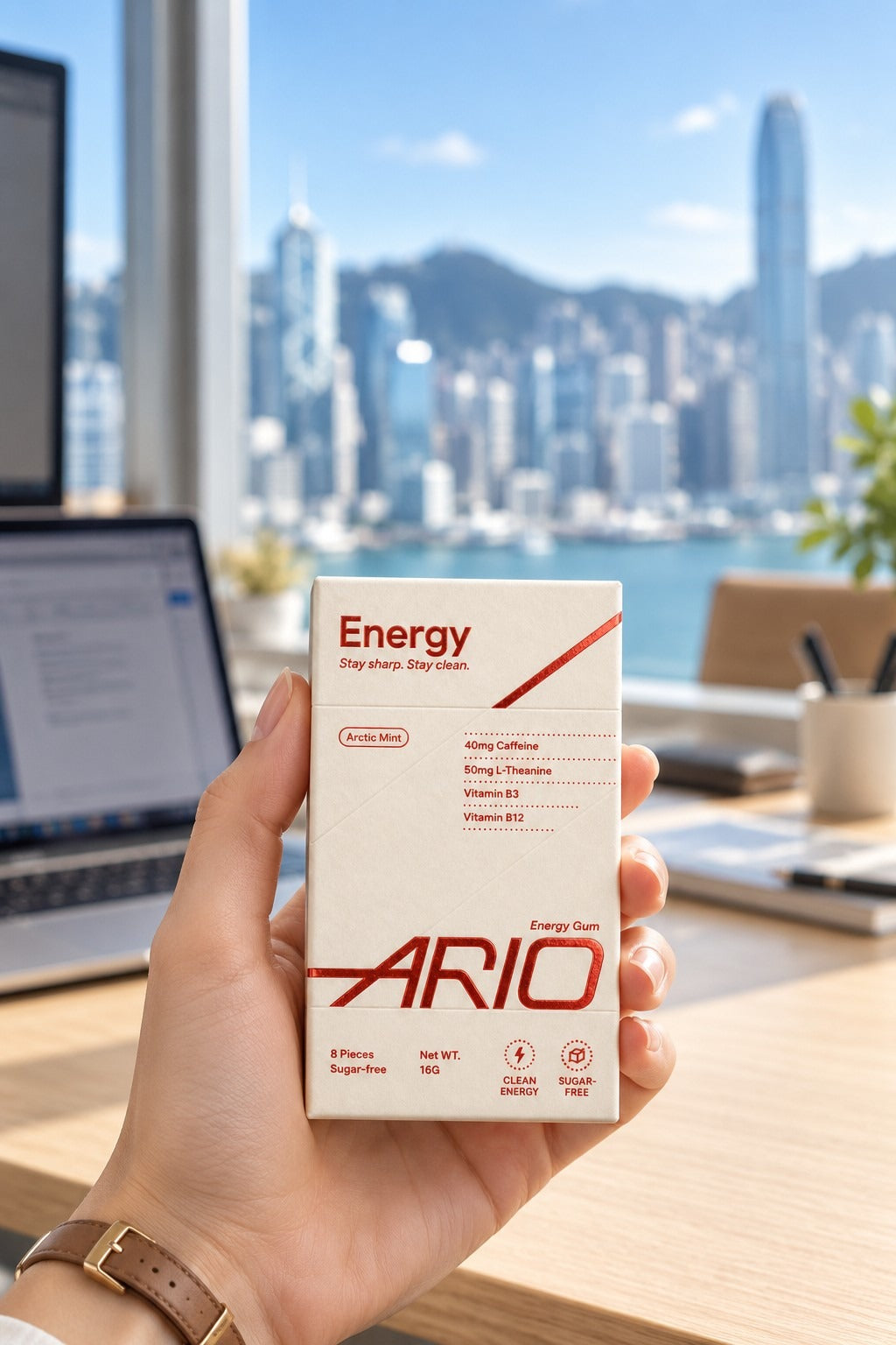 A hand holding the ARIO pack in an office overlooking Victoria Harbour
