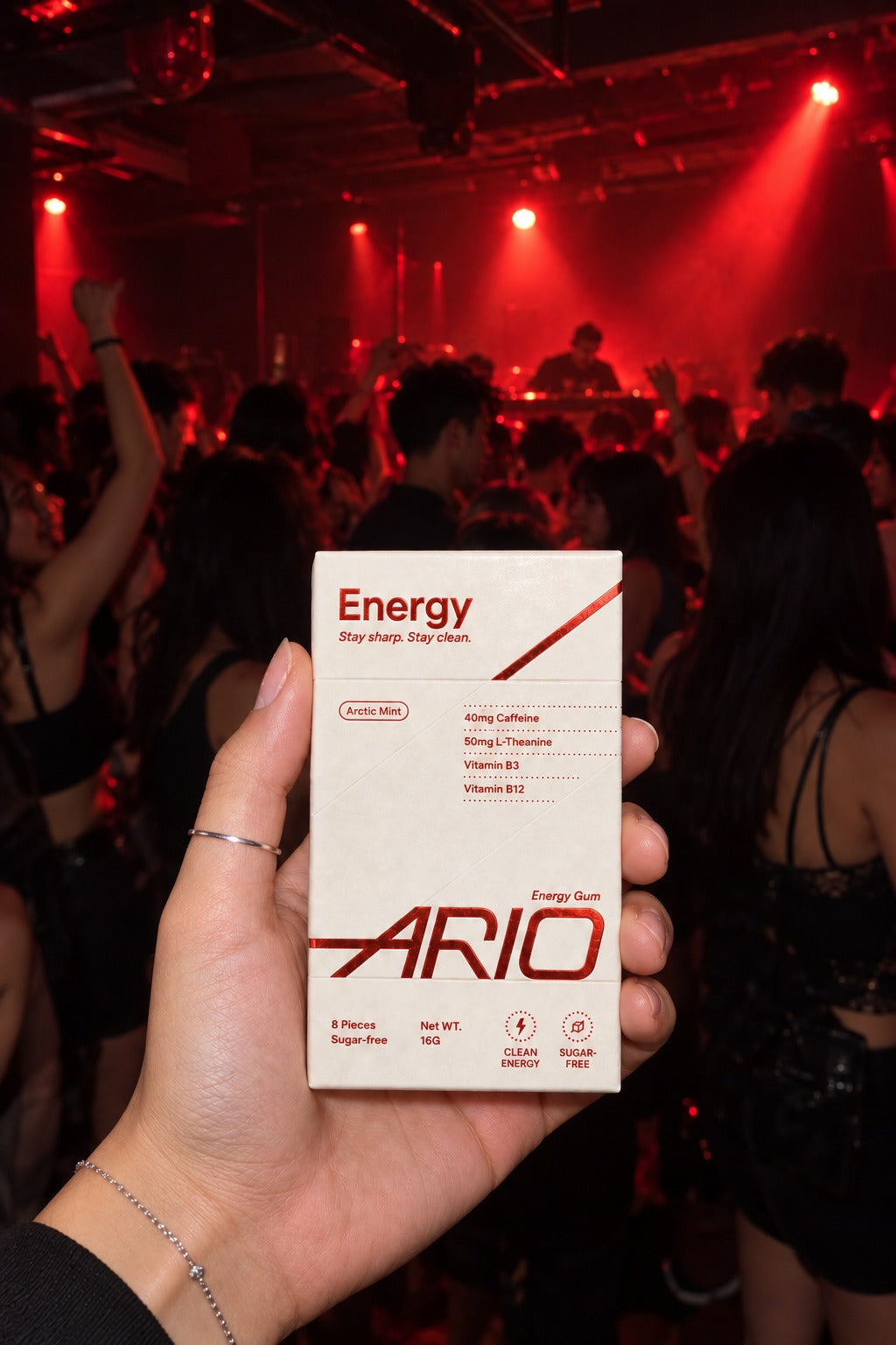 A hand holding the ARIO pack on a club dance floor at night